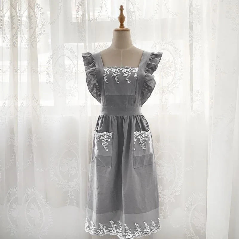 A gray ruffled cotton linen kitchen apron with lace trim displayed on a mannequin.