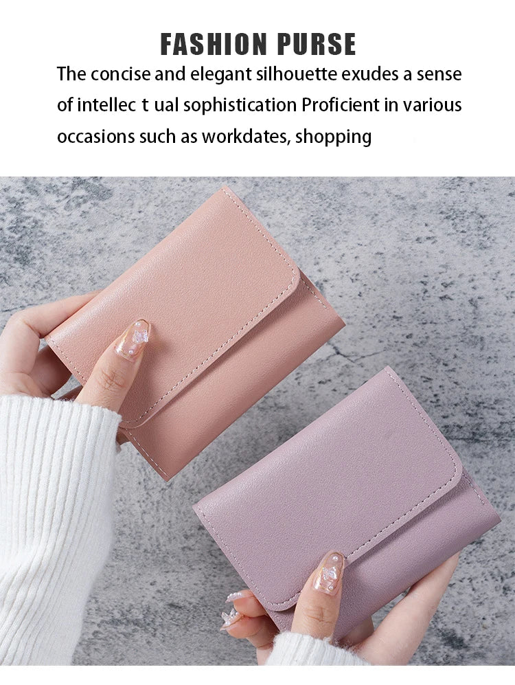 A close-up of a pink leather fashion purse being held by a hand against a gray background.