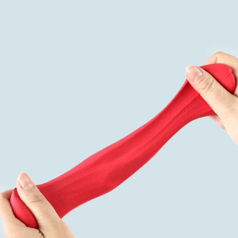 A hand is holding a bright red clay tool, demonstrating the texture and shape of the modeling material.