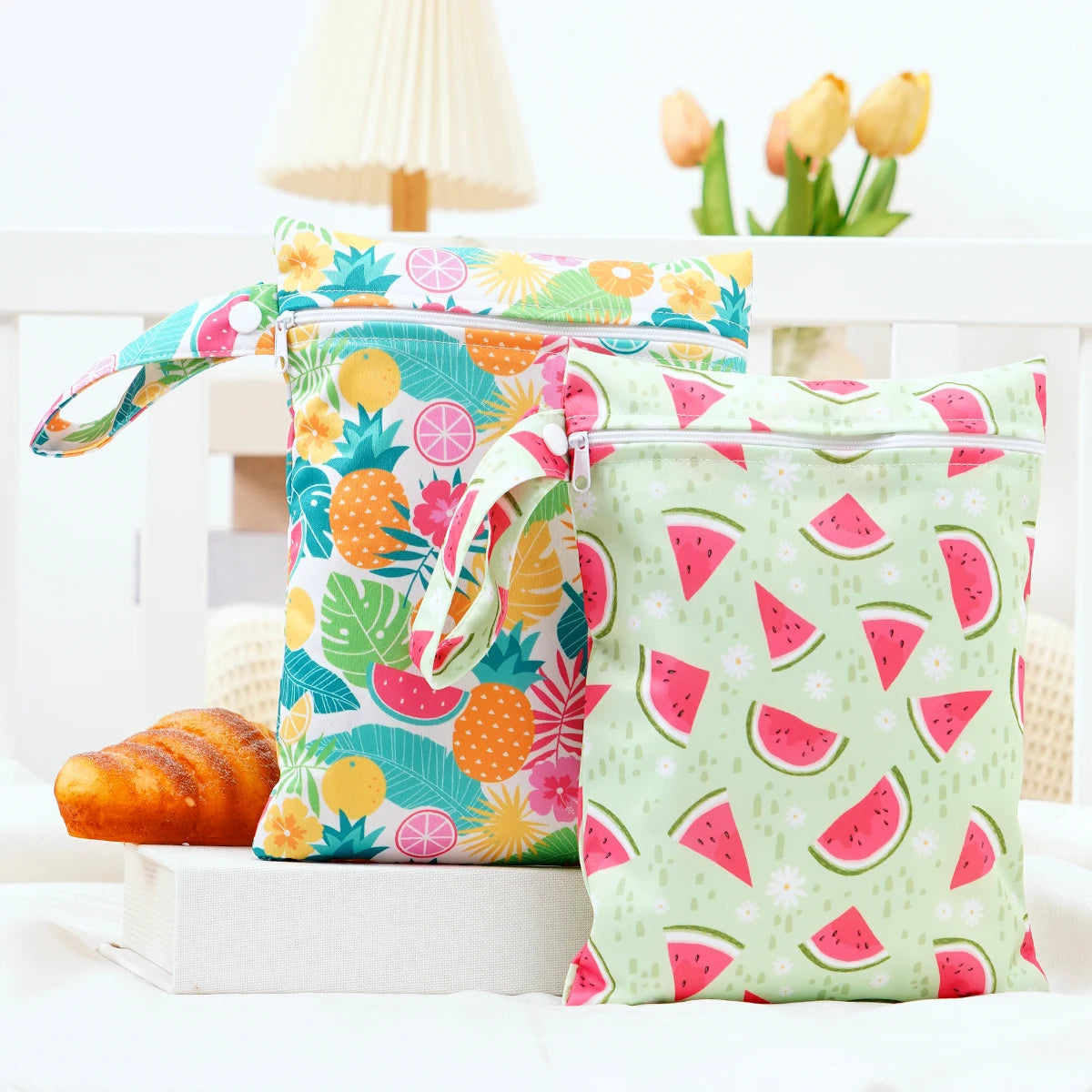 A pair of colorful, patterned mini waterproof wet dry bags featuring tropical fruit designs on a white surface.