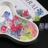 A white dish filled with colorful acrylic alphabet beads for jewelry making