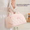 A light pink quilted PU leather insulated lunch tote bag being held by a person.
