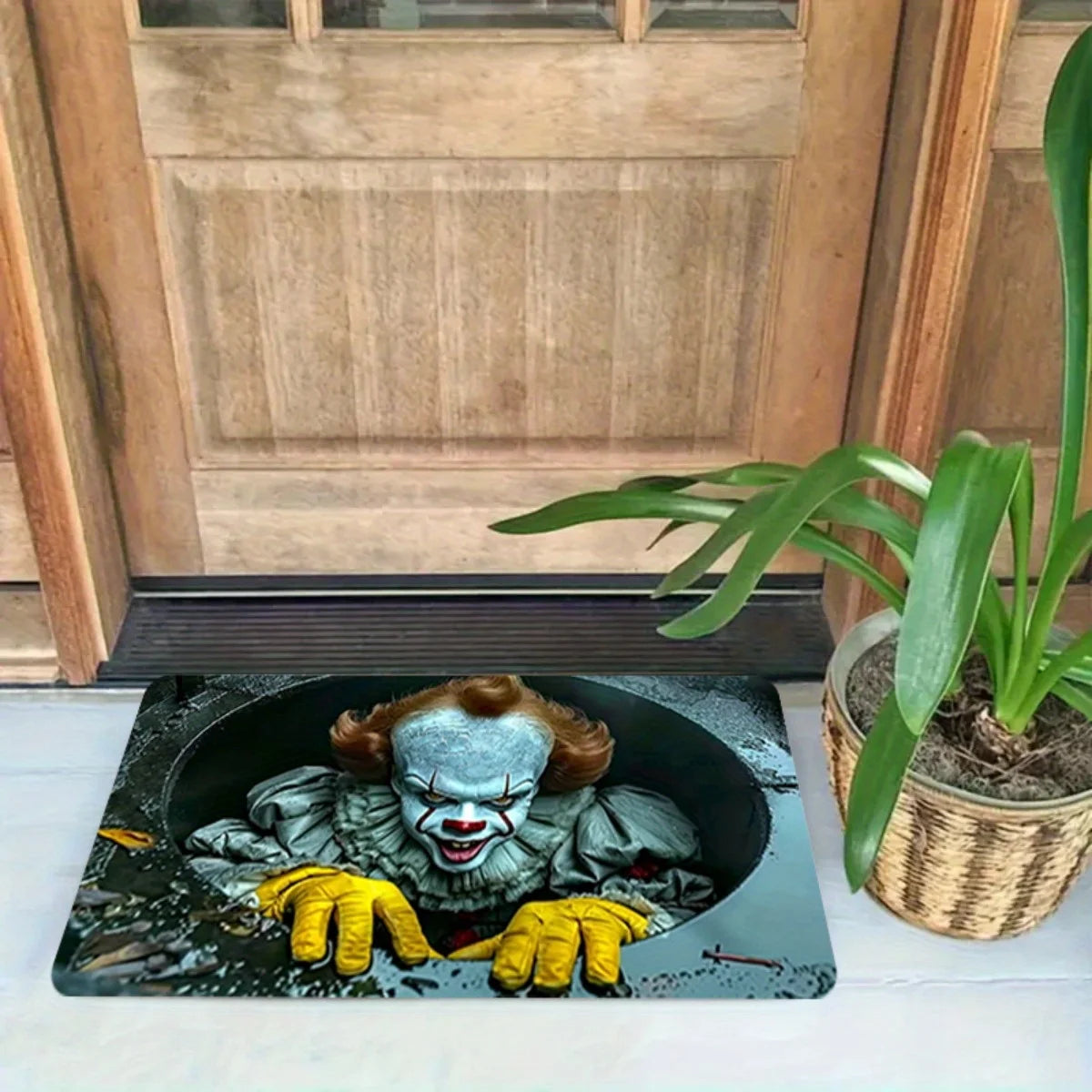 A black door mat featuring a distressed horror clown face with yellow gloves.