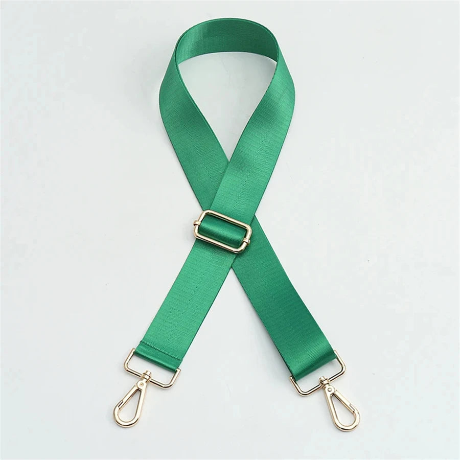 A green nylon bag strap with a gold buckle, shown in an 'X' shape.