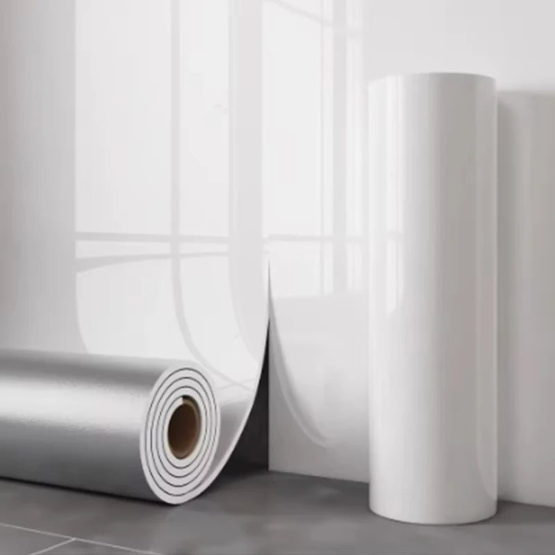 A roll of self-adhesive marble wallpaper showing a white cylindrical section against a light gray wall.