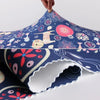 A close-up of a patterned fabric cover for a suitcase protector, featuring blue and pink floral designs.