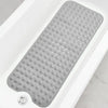 A gray non-slip bathtub mat with suction cups and drain holes is shown inside a white bathtub.