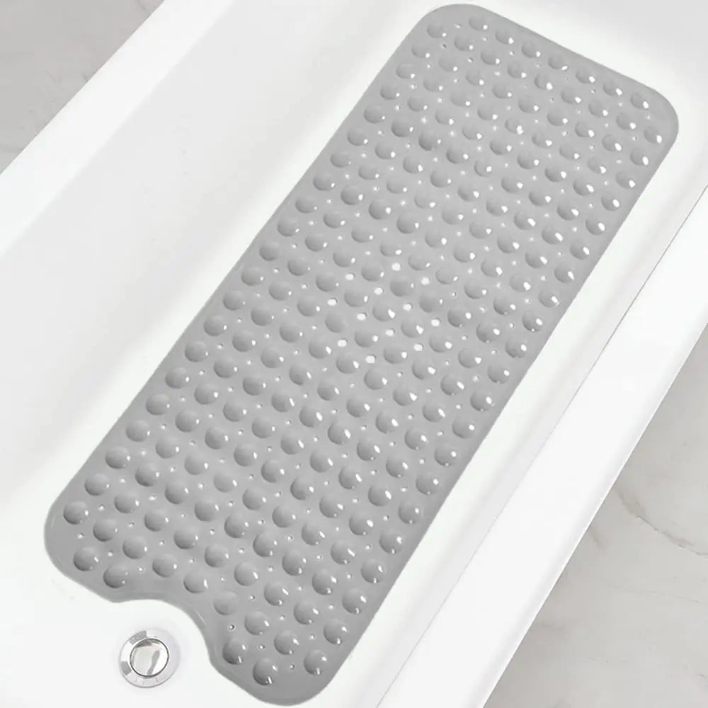 A gray non-slip bathtub mat with suction cups and drain holes is shown inside a white bathtub.