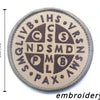 A round, tan embroidery patch featuring the acronym IHS and other symbols related to St. Michael.