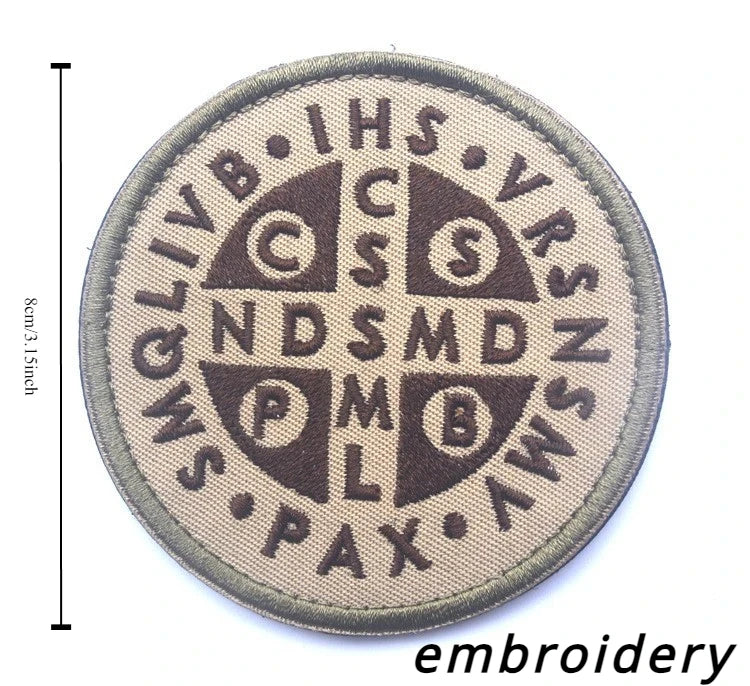 A round, tan embroidery patch featuring the acronym IHS and other symbols related to St. Michael.