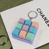 A purple tactile clicking keyboard keychain fidget toy with pastel colored buttons and a silver keyring.