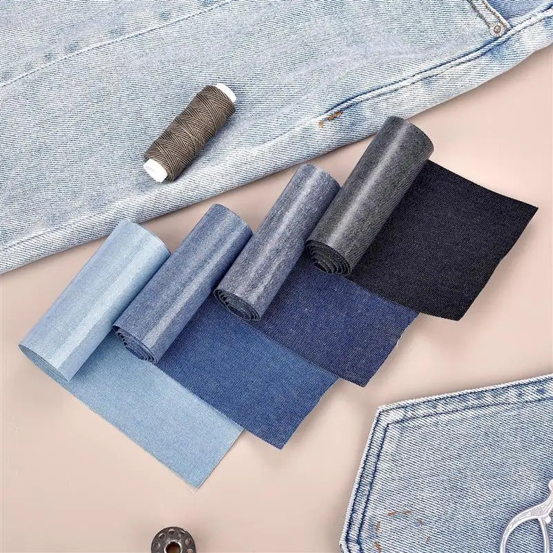 A collection of denim iron-on patches in various shades of blue and gray are displayed on a light pink background.