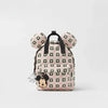 A pink and white cow print backpack featuring Mickey Mouse ears.