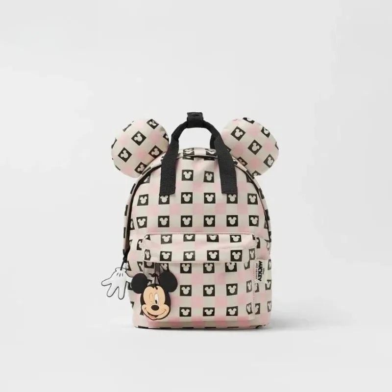 A pink and white cow print backpack featuring Mickey Mouse ears.