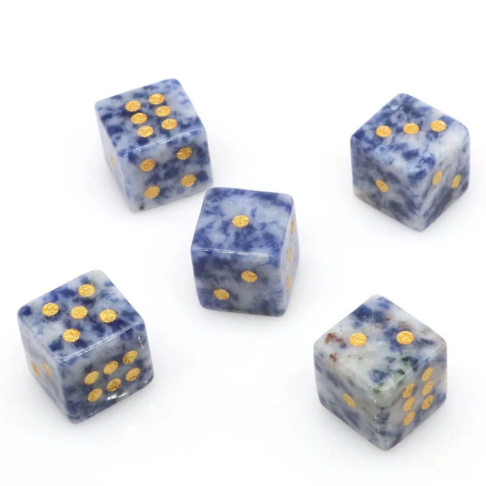 A set of natural stone D6 dice featuring blue lapis lazuli and obsidian with gold dots.