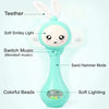A teal musical rabbit rattle and teether toy with soft lighting, colorful beads, and a sand hammer mode.