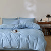 A light blue quilted duvet cover set with matching pillowcases on a bed.