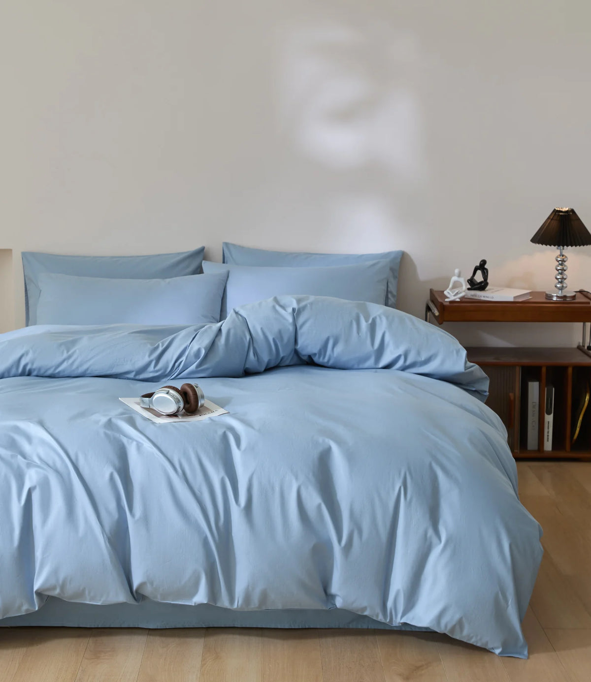 A light blue quilted duvet cover set with matching pillowcases on a bed.
