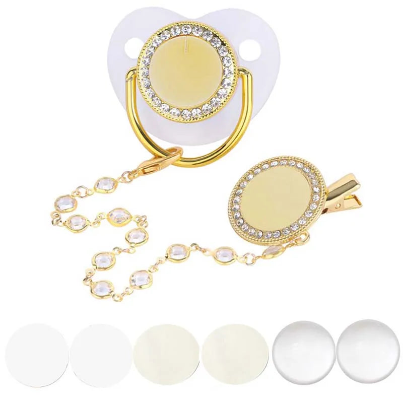 A sparkling rhinestone pacifier with a clip for babies shown next to several white silicone pacifiers.