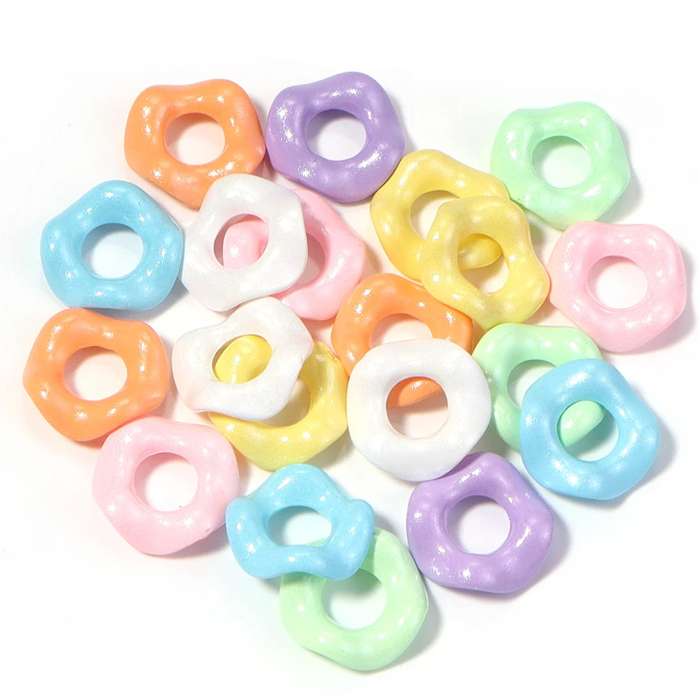A collection of colorful acrylic spacer beads in a wave pattern, including pink, yellow, purple, and blue shades.
