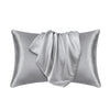 A silver satin pillowcase with a draped fabric detail.