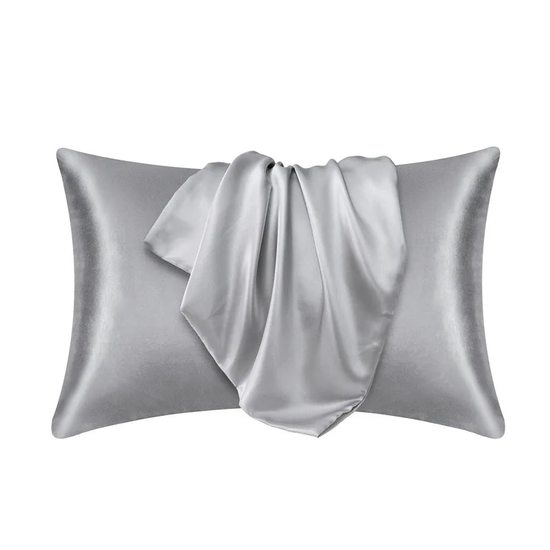 A silver satin pillowcase with a draped fabric detail.