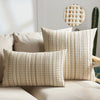 Two beige linen pillow covers with a textured pattern are displayed on a light sofa.