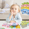 A toddler smiles while interacting with a set of colorful flash cards and learning toys.