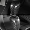Close-up of a glossy black carbon fiber gear shift knob cover for a Toyota Camry or Corolla.