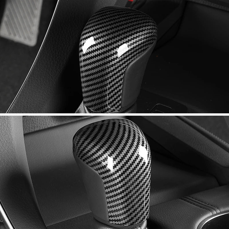 Close-up of a glossy black carbon fiber gear shift knob cover for a Toyota Camry or Corolla.