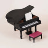 A black 1:12 scale dollhouse piano with a lid open, featuring a miniature keyboard and a pink bench.