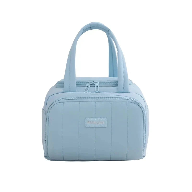 Light blue insulated quilted lunch tote bag with a handle and pocket detail