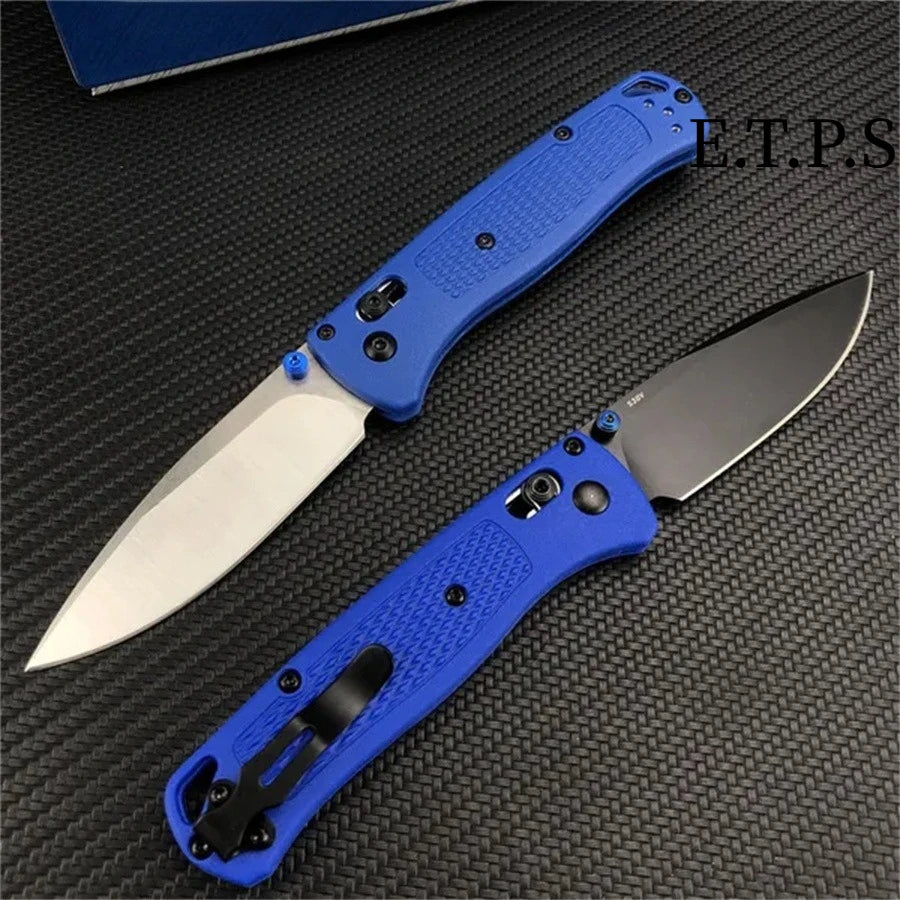A blue folding pocket knife with a drop point blade resting on a dark surface.
