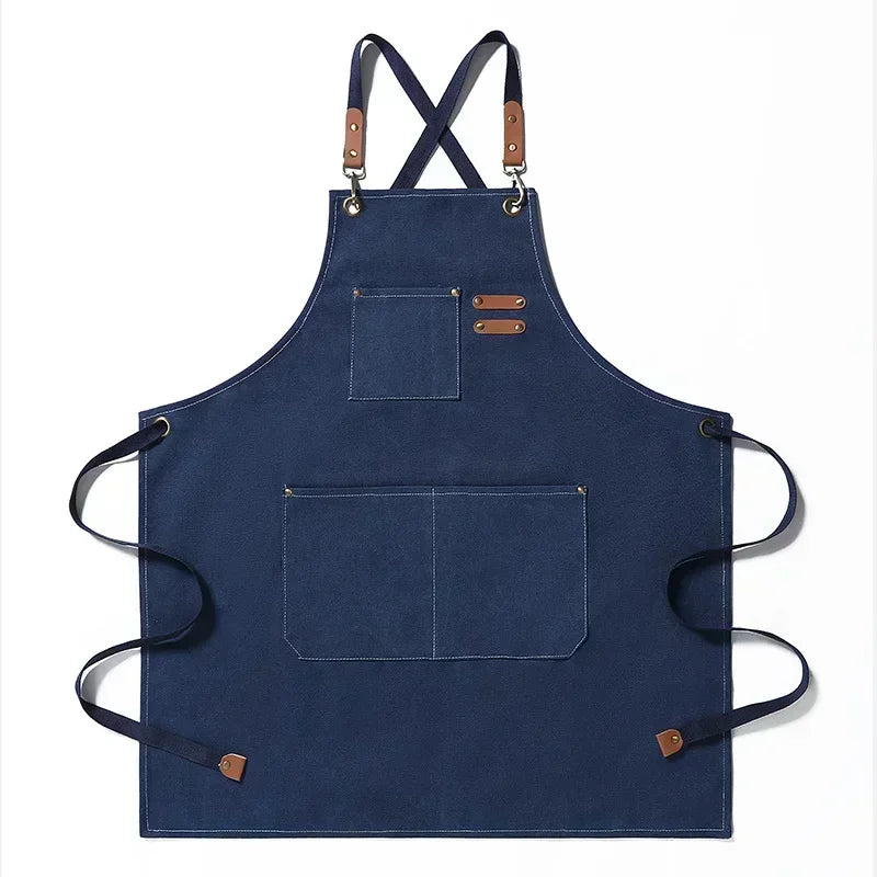 Navy blue cotton canvas apron with cross-back straps and multiple pockets