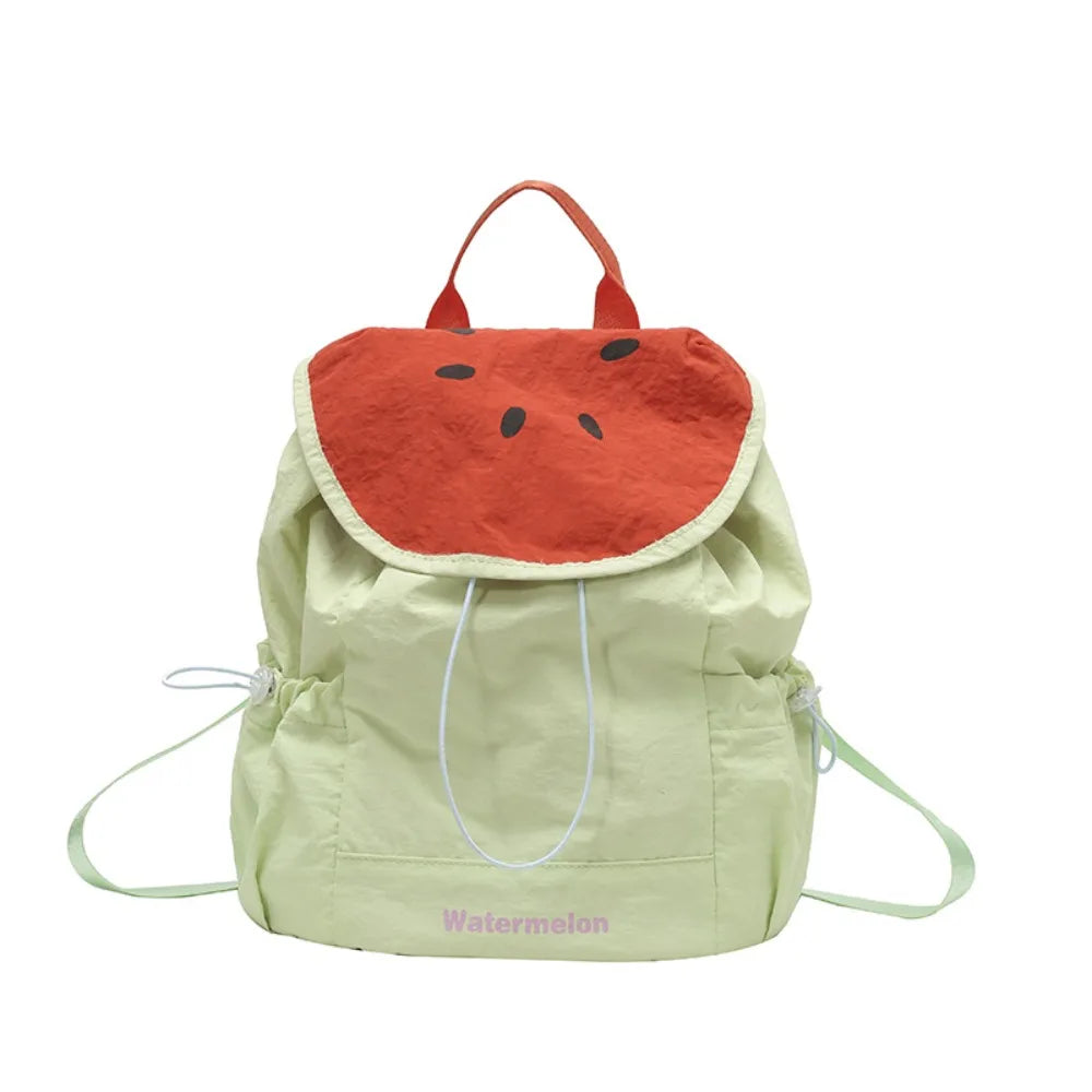 A light green nylon messenger bag shaped like a watermelon with an orange rind and black seeds.