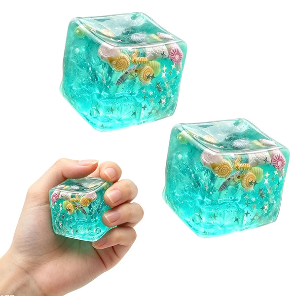 Eine Hand hält einen durchsichtigen türkisen Stressball mit glitzernden floralen Designs.