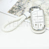 Silver key fob with panic button and lock buttons attached to a white cord