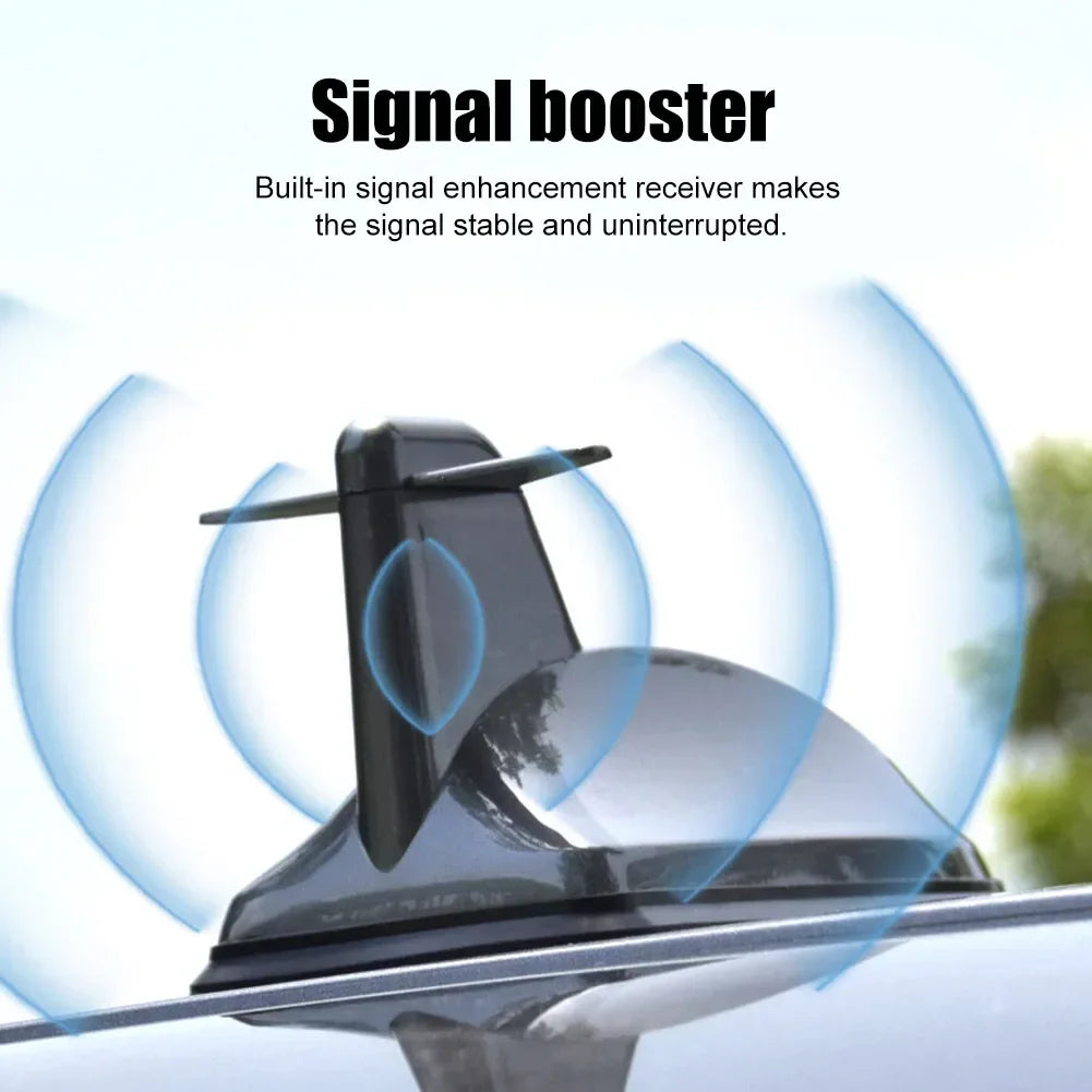 A black shark fin car antenna with a built-in signal booster is shown mounted on a vehicle.