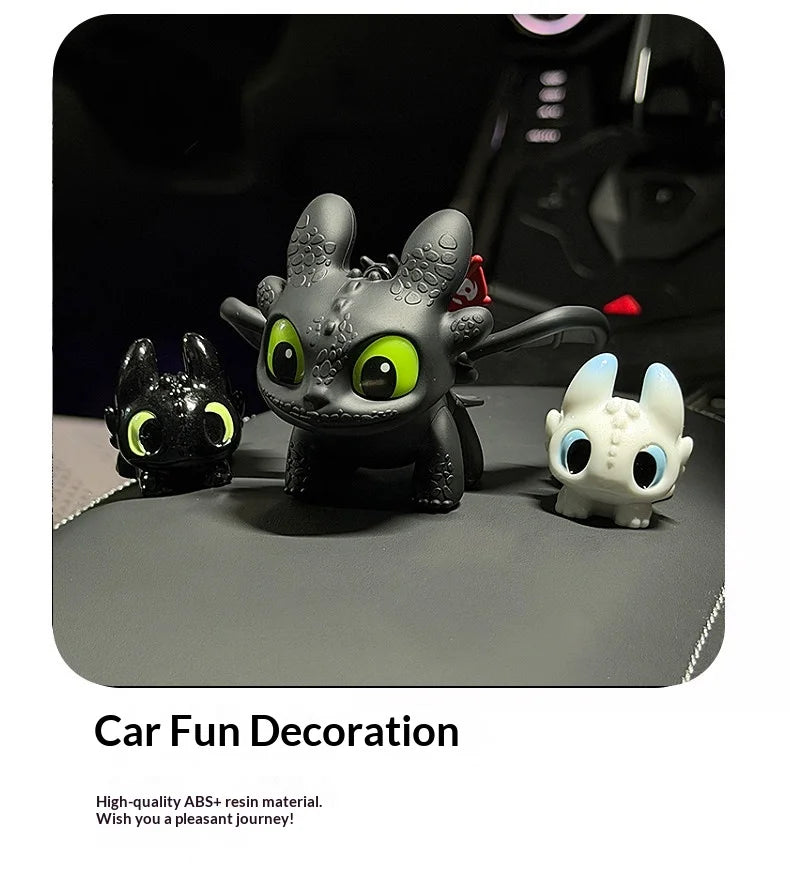 Three black and white Toothless-inspired resin car decorations with movable wings displayed on a gray surface.