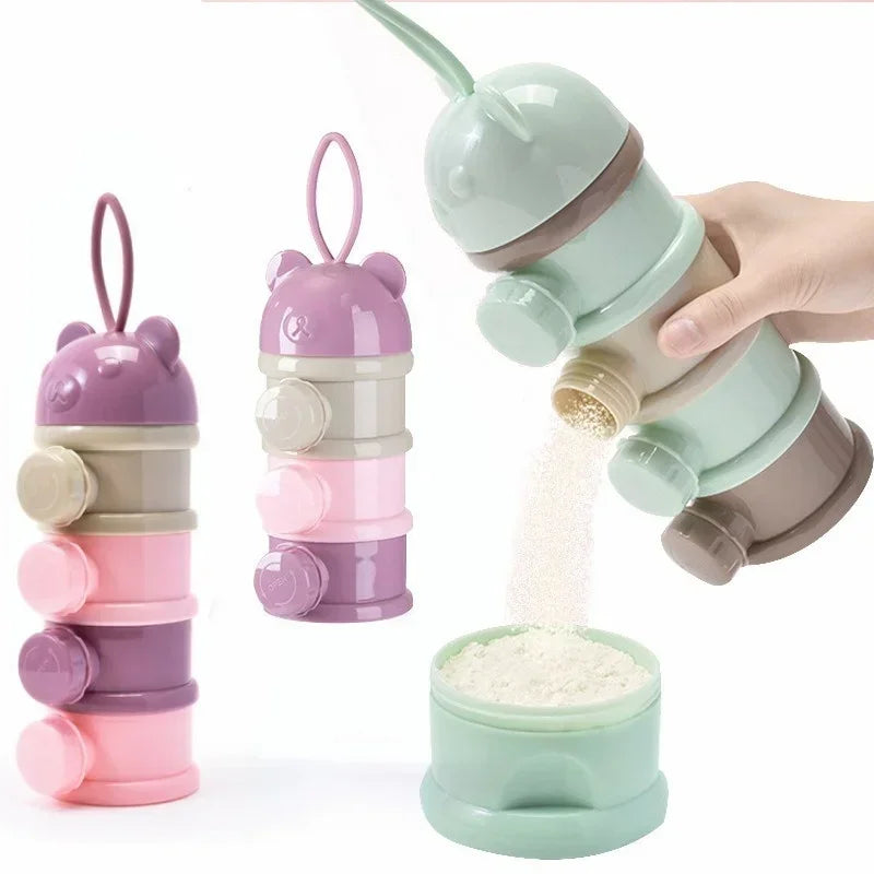 A hand is holding a stack of three bear-shaped baby food storage containers in various shades of pink and green, with some po