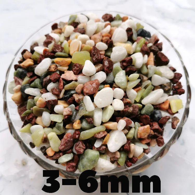 A close-up view of mixed decorative stone pebbles in various shades of brown, green, and white.