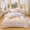 A floral printed duvet cover set with pillows displayed on a bed near a window.