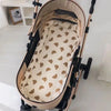 A beige padded seat cushion for a baby stroller, featuring a light fabric and brown accents.