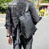 Person in dark denim jacket and jeans carrying a black leather backpack