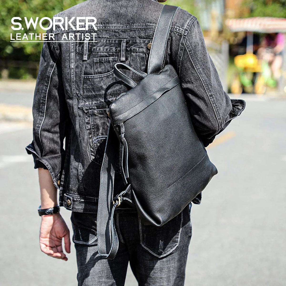Person in dark denim jacket and jeans carrying a black leather backpack