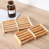 A set of wooden foot massage rollers for reflexology and tension relief resting on a light wooden surface.