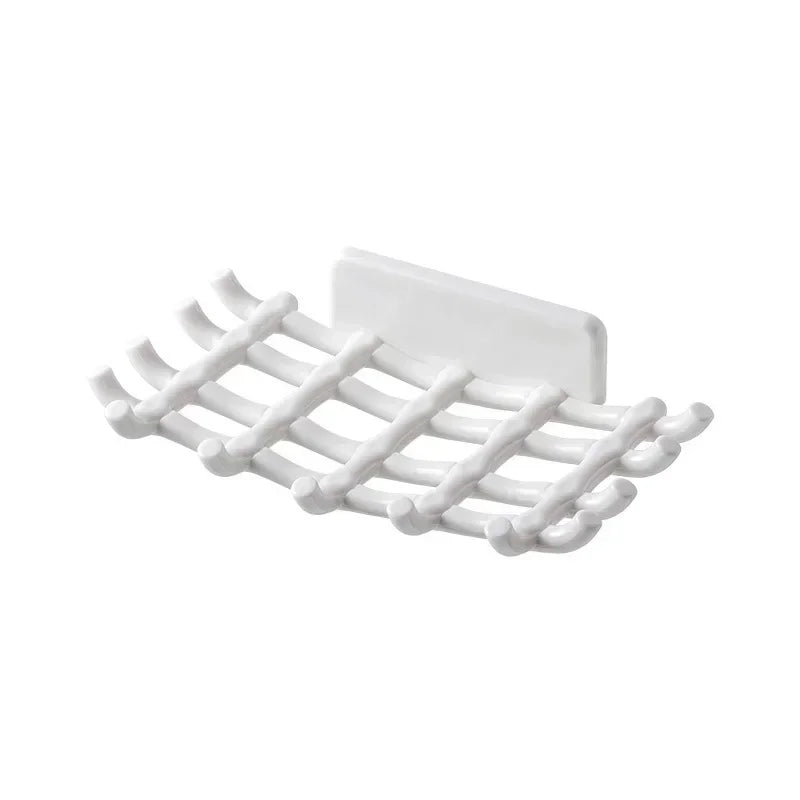 White wall-mounted soap dish with drainage holes.