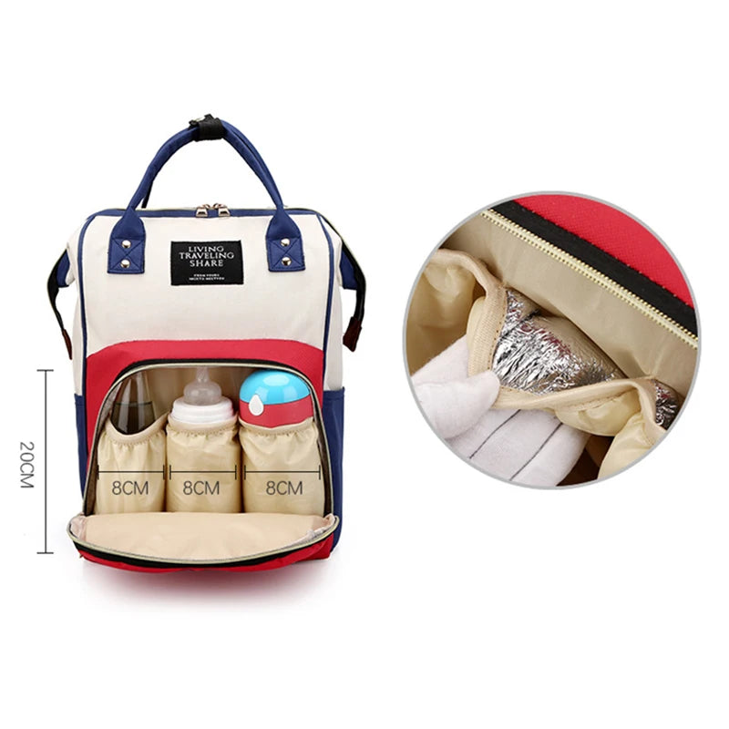 A beige and red insulated canvas mummy diaper bag with a hanging hook, showing the interior compartments.
