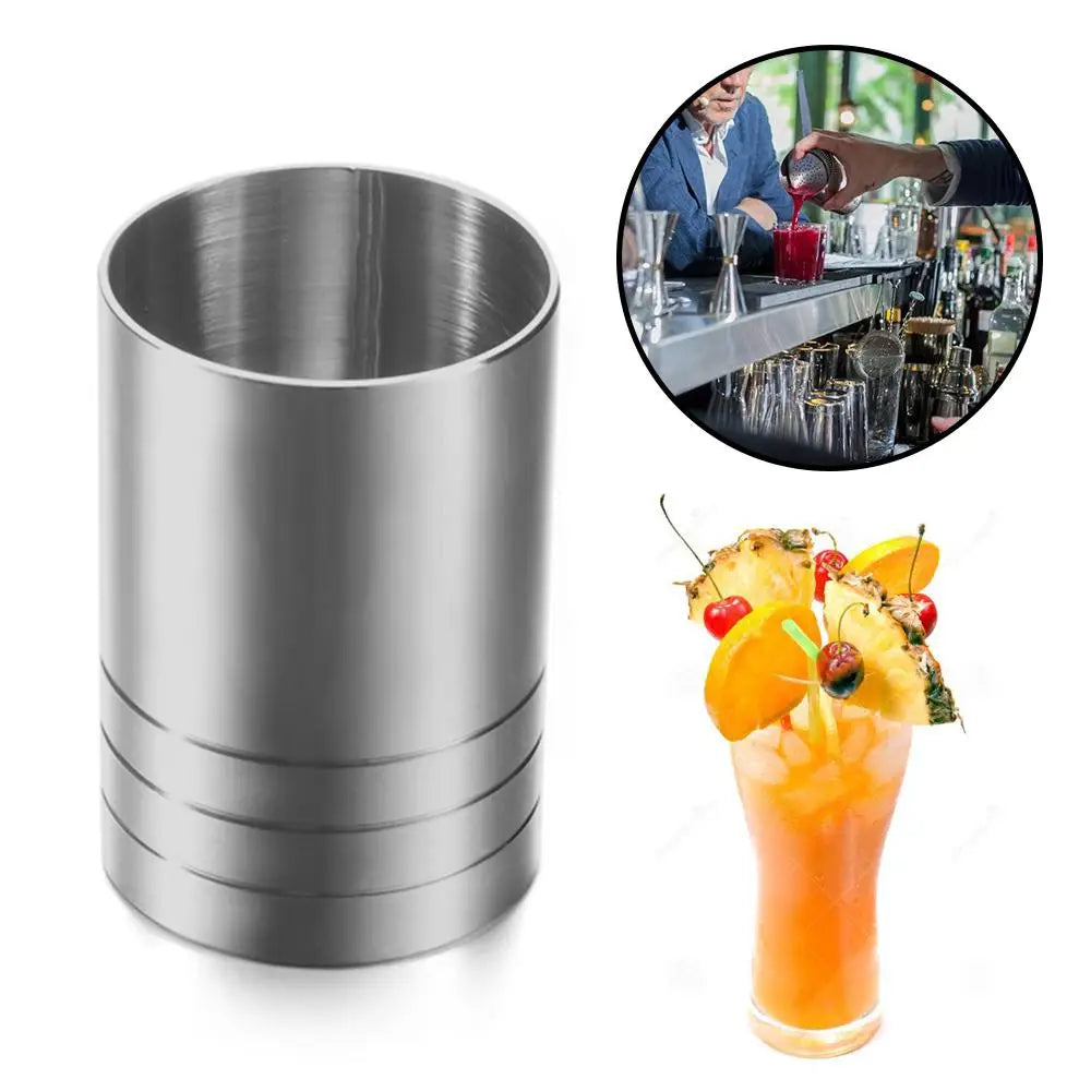 Edelstahl-Messbecher neben einem Cocktail in einem Glas