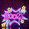 A neon sign shaped like the word BOOM in bright pink and blue light, displayed against a dark background.